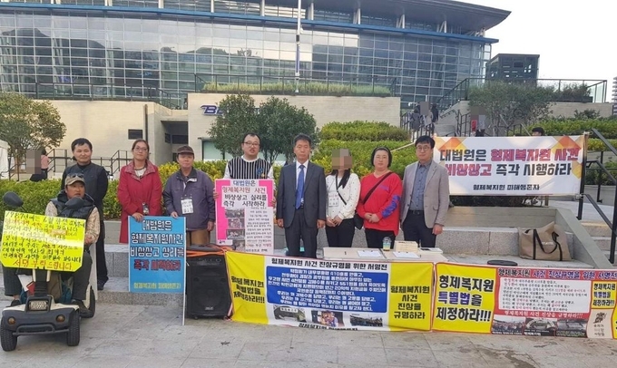 형제복지원 피해생존자들이 관련 사건 대법원 비상상고 시민 서명부(약 6천 명)를 22일 오전 대법원에 전달한다고 밝혔다. 피해생존자 이향직(왼쪽에서 다섯 번째 줄무늬 상의) 씨는 "이 작은, 보잘것없는 꿈틀거림에 관심 가져 주시길 당부드린다"고 전했다. 우측에서 네 번째 형제복지원 사건 수사 검사 김용원 변호사, 맨 오른쪽 박민성 부산시의원. 2019년 11월 2일 부산역광장. 사진 형제복지원 피해생존자 제공