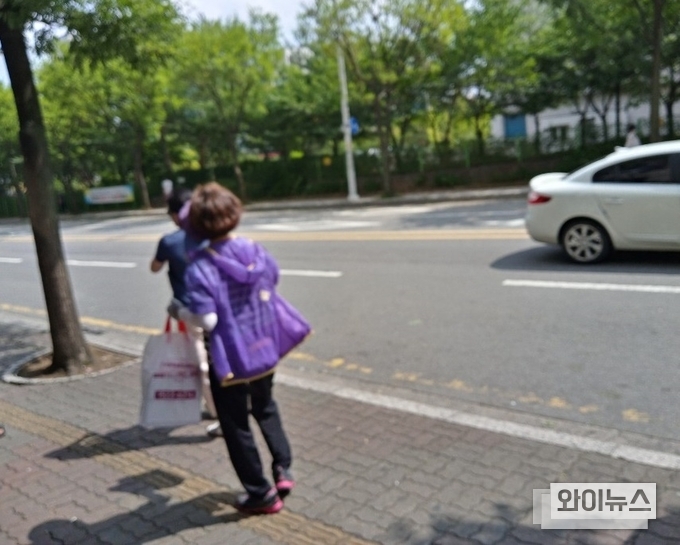 마케팅을 위해 상품을 손에 든 여성이 피해 뛰어 도망치는 시민을 집요하게 뒤쫓고 있다. 이 여성은 시민을 쫓아 10여 미터 정도 뛰어갔다. 