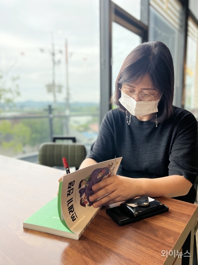 신혜순 동화작가가 대학 동기들과의 만남에서 자신의 책에 사인을 하고 있다. 
